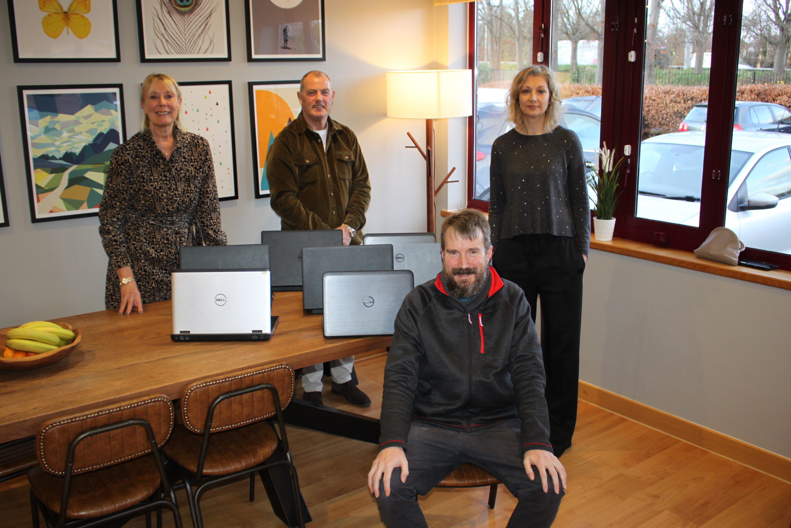Kate and Rob Allen and Eleanor Bromage pose with John Dennis from Aspire with the seven laptops