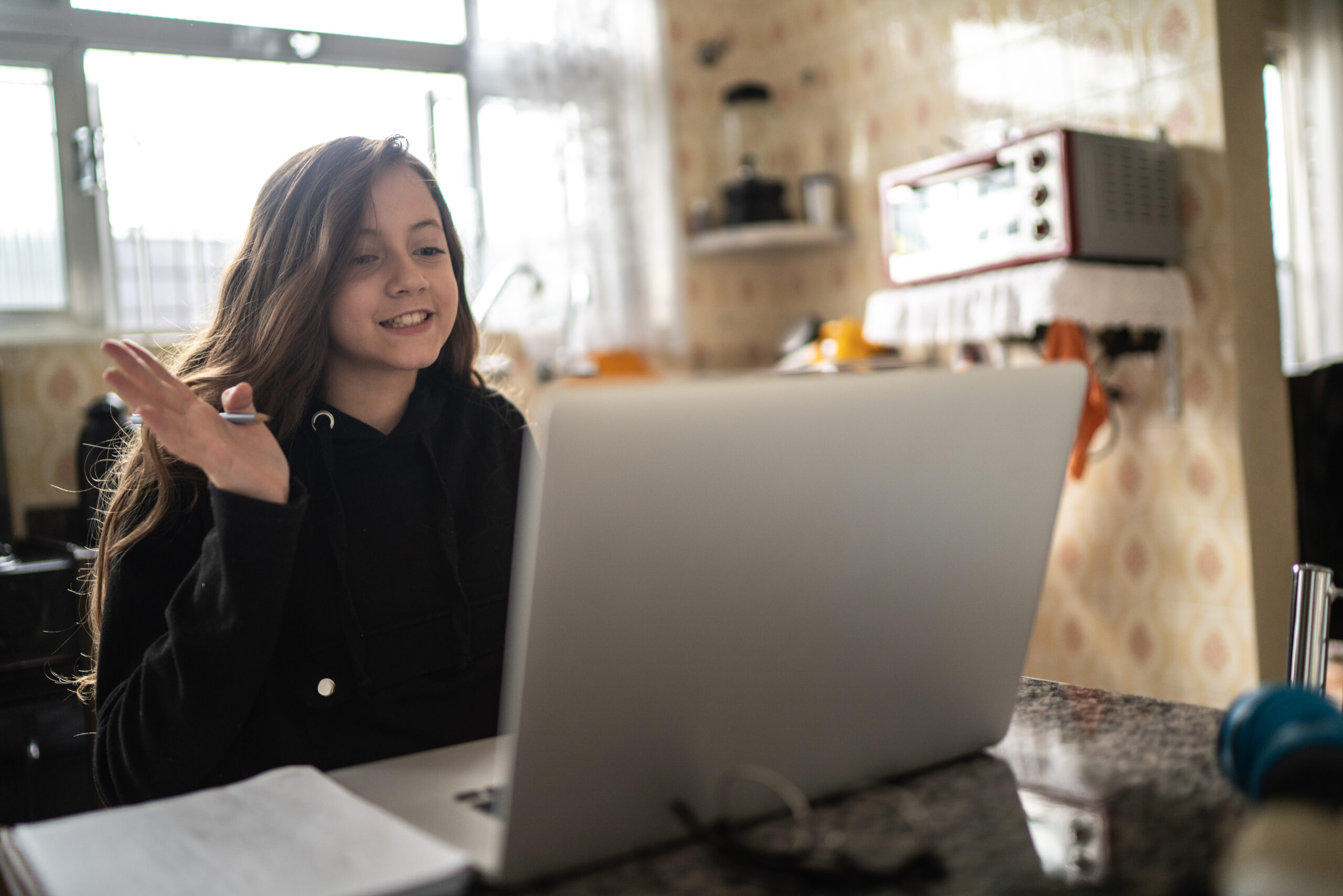 Girl studying and making a video call via laptop at home