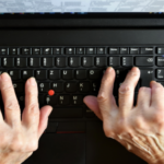 Hands of an older person on a keyboard